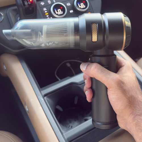 Hand holding a cordless handheld car vacuum cleaner