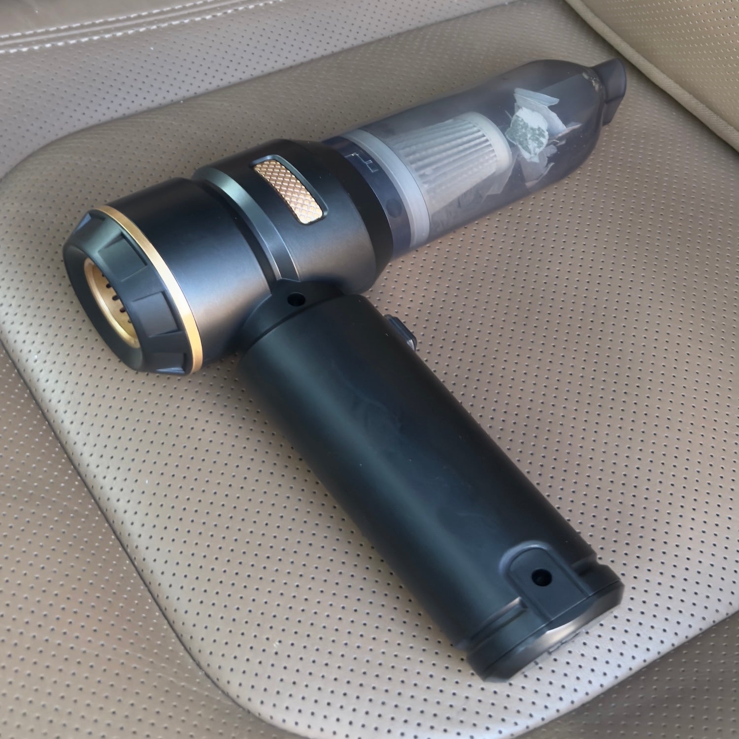 portable cordless handheld car vacuum cleaner resting on a car seat