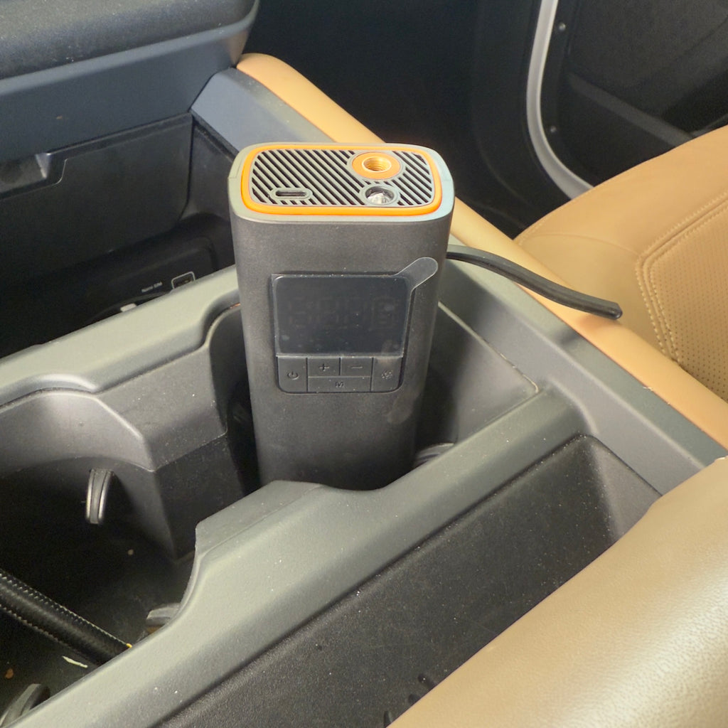 Portable tire inflator stored in a vehicle cup holder